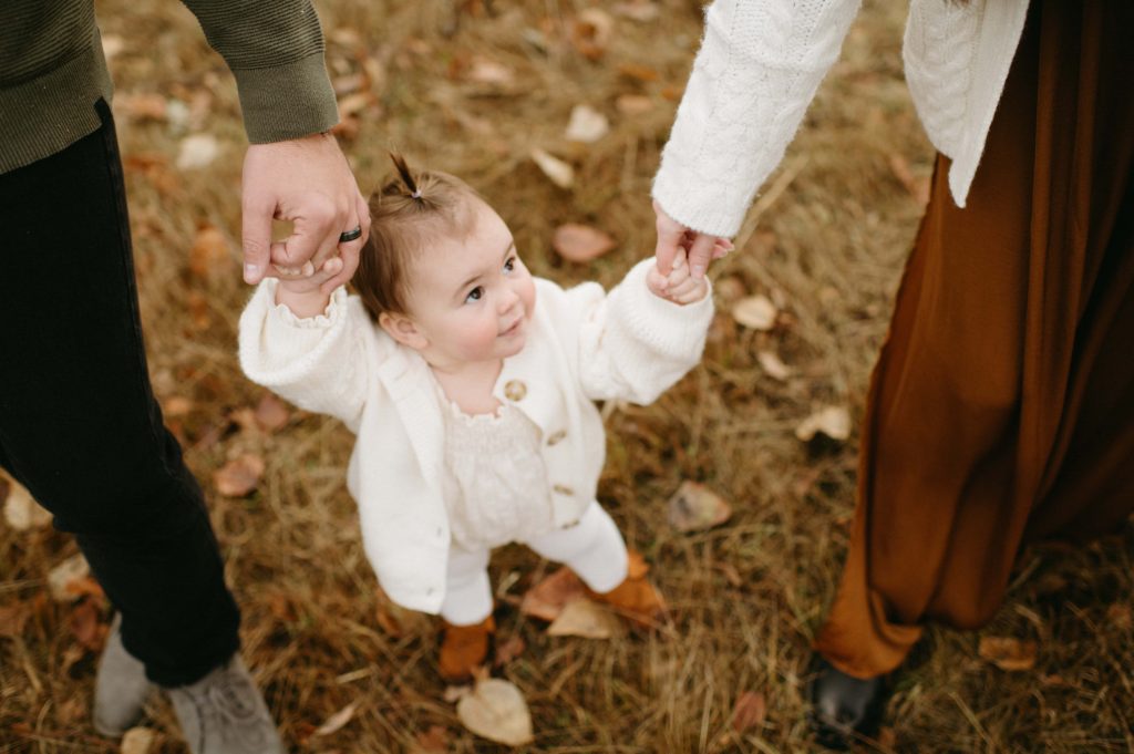 baby girl holding parent's hands