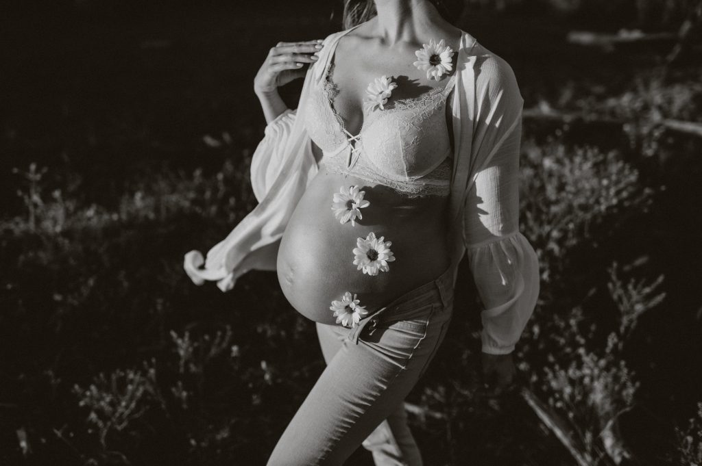 Pregnant woman with flowers on belly 
