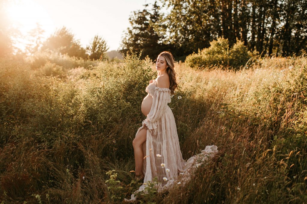 Pregnant woman in tall grass and gown