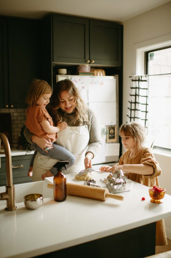 mom and 2 girls baking together in kitchen