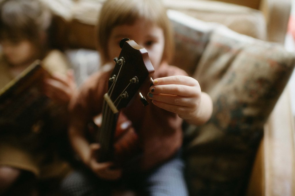 little girl tuning guitar family photography session